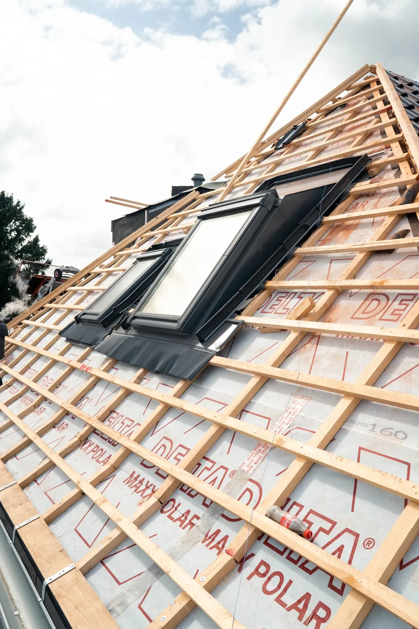 Freigelegter Dachstuhl mit neuer Konterlattung, Unterspannbahn und eingebautem Dachflächenfenster während einer energetischen Sanierung